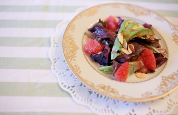 Citrus Bridal Shower, gold trimmed plate, lace doily, citrus salad, avocado, green striped tablecloth