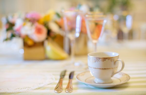 Citrus Bridal Shower, green striped tablecloth, gold flatware, gold teacup